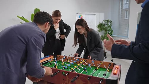 Group of Colleagues Playing Foosball in Modern Office Setting