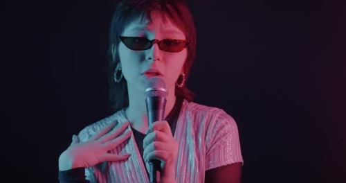 Woman Singing into Microphone with Stage Lights