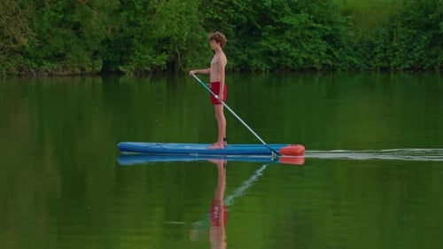 Teenager with Paddle on a Sup Floats on a Picturesque Lake Active Lifestyle Concept
