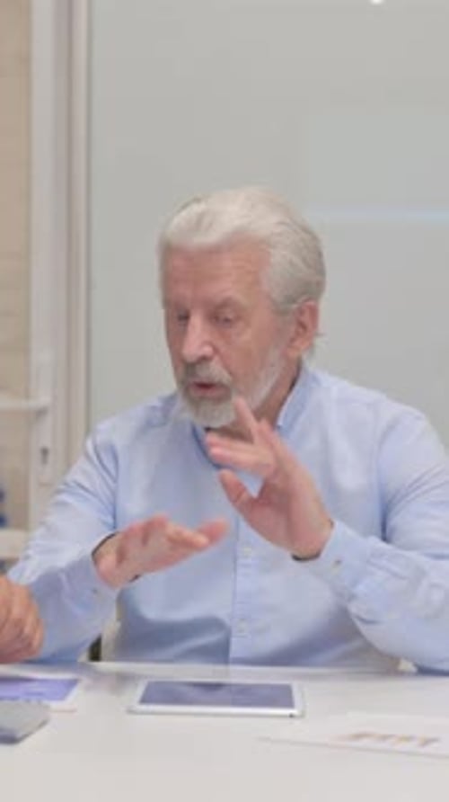 Senior Man Discussing Business Tablet Data in Office