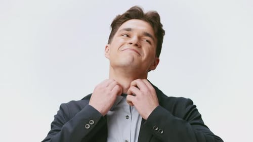 Selbstbewusster junger Mann steht vor einem isolierten Hintergrund mit stilvollem Look