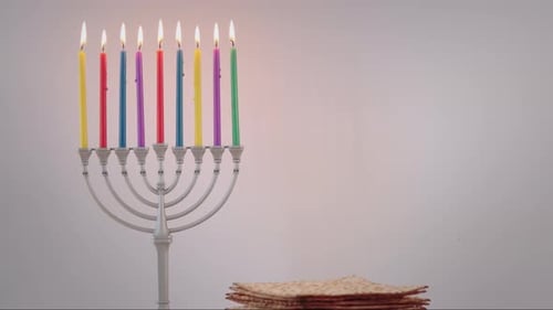 Velas navideñas encendidas para Hanukkah en el telón de fondo blanco de la menorá de Hanukkah en el hogar