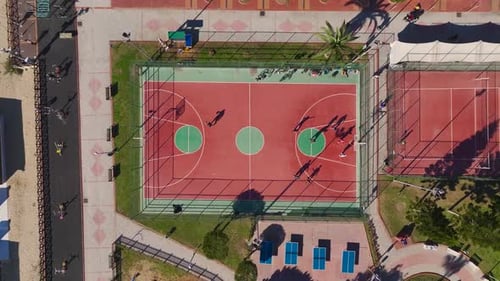 Aerial Video Active Basketball Game on an Outdoor Court With Players Moving Quickly Captured From