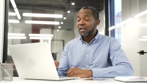 Man Talking on Video Call in Modern Office
