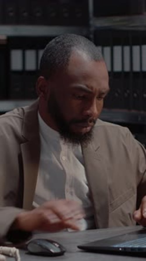 Man Reviews Documents at Desk