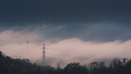 Aerial view high voltage power transmission towers or electricity pylon in fog.