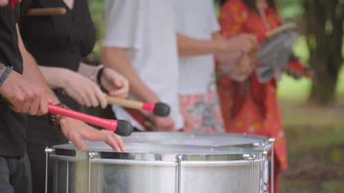Musician playing bass drum in park Percussion orchestra playing in park