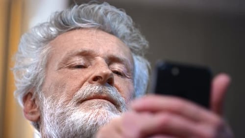 Senior Adult Using Smartphone Indoors, Close Up