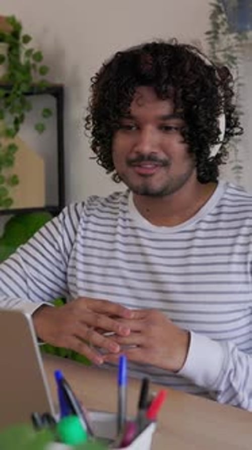 Young Adult Indian Man in Video Call Using Laptop at Home Office