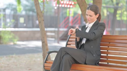 Woman in Business Suit Looking at Smart Watch