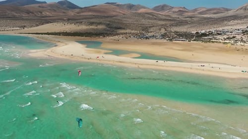 Kitesurfing in turquoise water at Sotavento beach in Fuerteventura