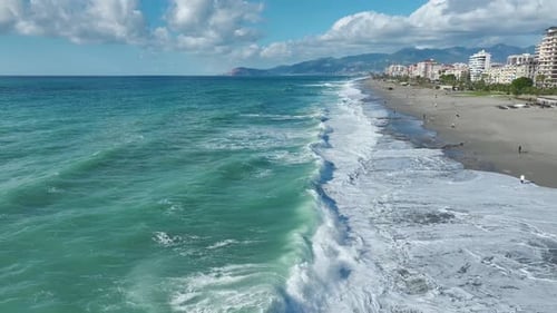 Aerial Video Powerful Ocean Waves and Swirling Foam Cover the Beach During a Storm