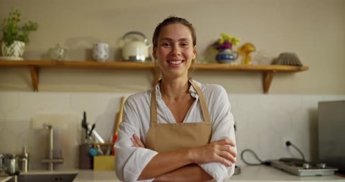 Smiling Woman with Arms Crossed in Kitchen