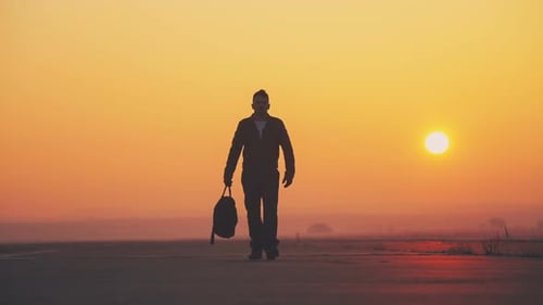 Silhouette Brave Man with Bag Walking at Sunrise
