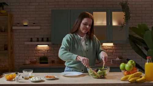 Young Woman Prepares Fresh Salad in Her Kitchen
