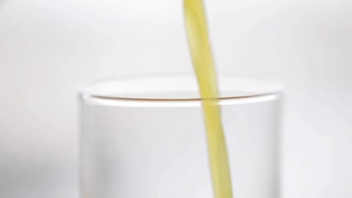 Bright Yellow Liquid Being Poured into a Glass