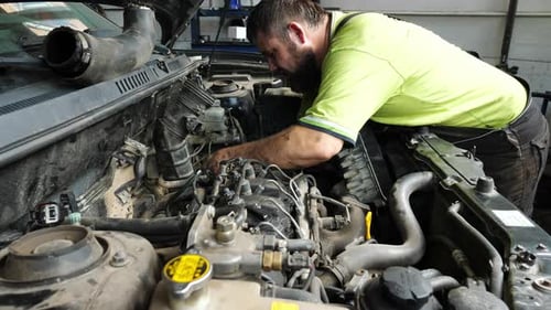 Male Repairer Making Maintenance of Car at Garage Adult Auto Mechanic Working Under Hood of Vehicle