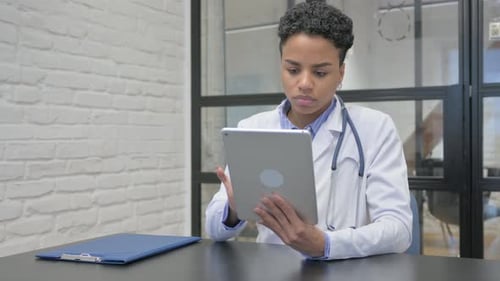 Young Woman Doctor Using Tablet in Office