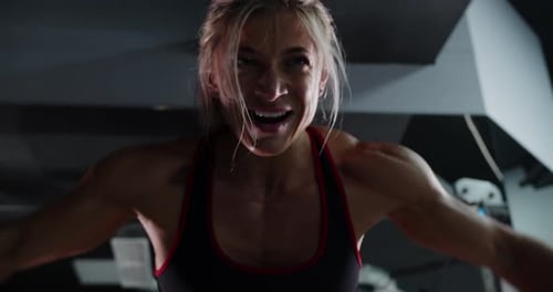 Muscular Woman Bodybuilder is Training in the Gym