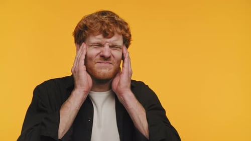 Young Man with Headache Rubbing Temples in Distress