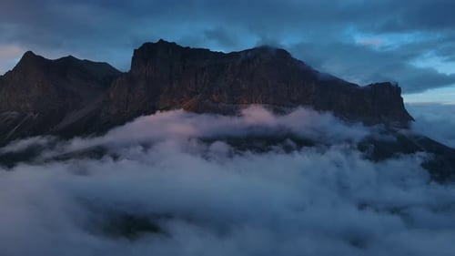 Mountain Enveloped By Clouds Against a Serene Blue Sky