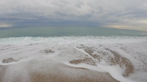 Coarse sand beach sea wave in slow motion at 120fps 4k cloudy day turquoise water single sea waves B