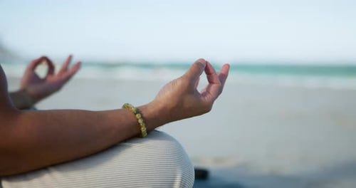 Person, hands and beach with meditation for spiritual wellness, chakra or zen on ocean coast