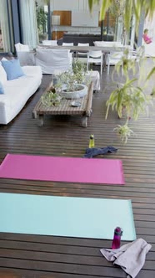 Water bottles, towels and exercising mats on sunny terrace