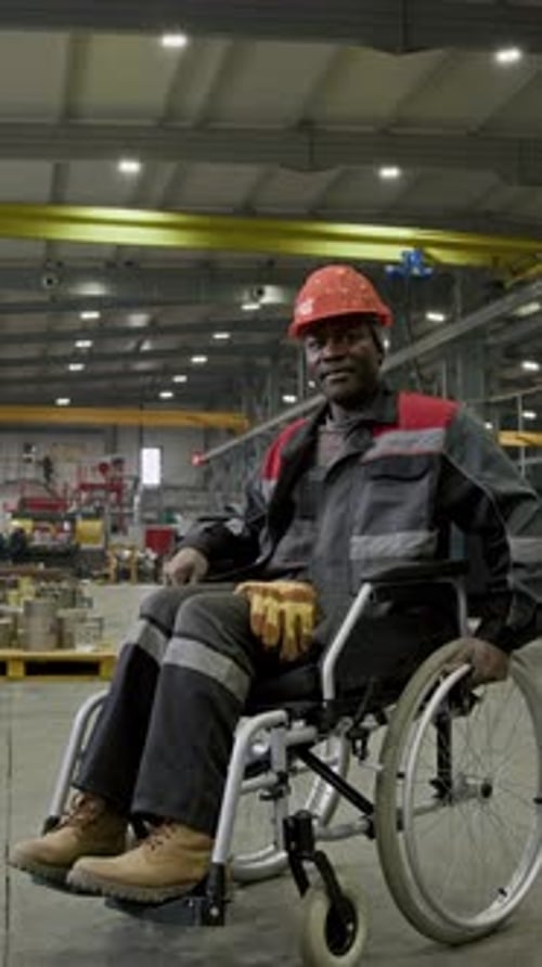 Vertical Portrait of Factory Worker with Disability Posing in Wheelchair