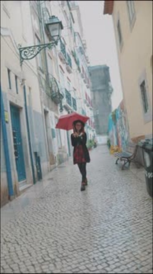 Stylish Woman Walking with Red Umbrella on Cobblestone Street