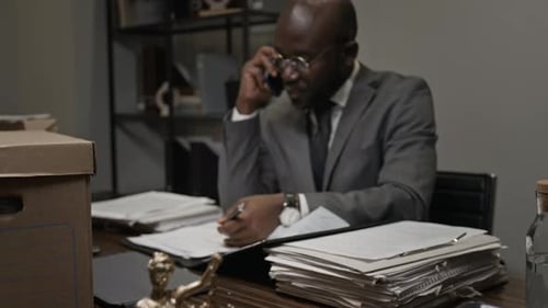 Angry Black Male Lawyer Arguing on Phone with Colleague over Legal Documents