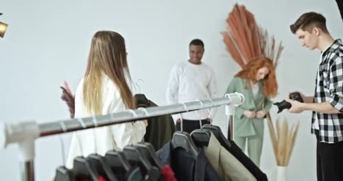 Professionelle Fotografie Backstage-Stylist wählt Kleidung für Models aus Multiracial Fotoshooting