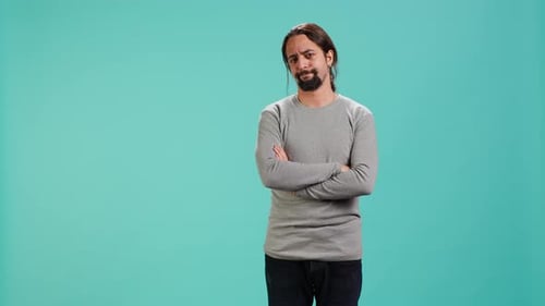 Man With Arms Crossed Against Blue Background