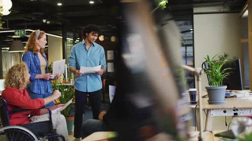 Happy disabled and diverse business people discussing work at office
