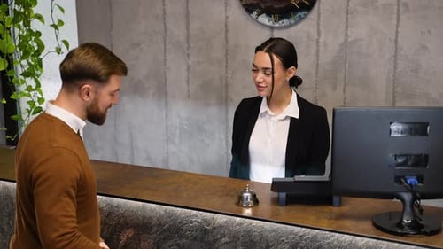 Hotel Receptionist Greeting Guest and Providing Room Key Card