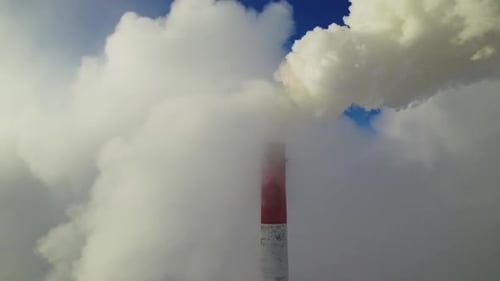 Industrial Chimney Emitting Thick Smoke into Blue Sky