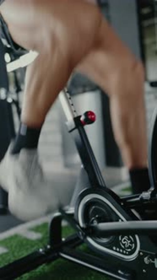 Konzentrierter Mann, der im Fitnessstudio für Cardio-Fitness am Rudergerät trainiert
