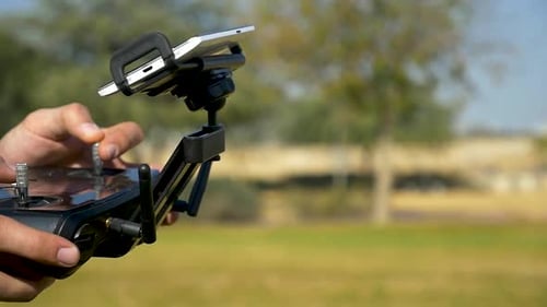 Close Up View drone pilot operating professional quadcopter. Trucking left camera.