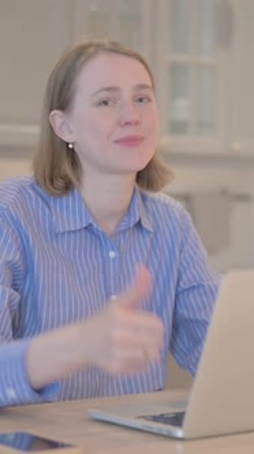 Smiling Woman Working on Laptop Gives Thumbs Up