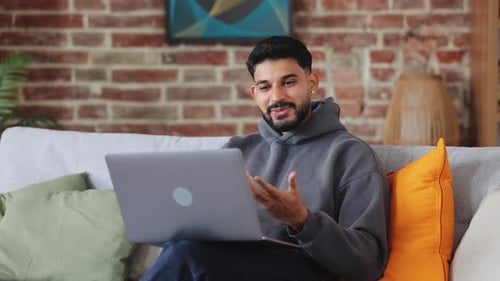 Man Video Calling on Laptop While Sitting on Couch
