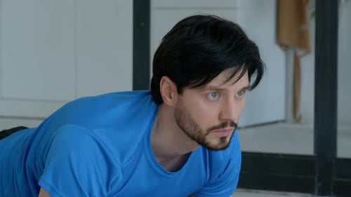 Man in Blue Shirt Exercises at Home