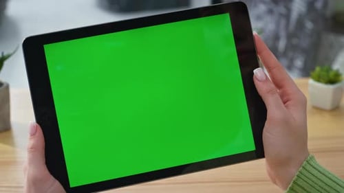 Woman Hands Holding Green Screen Tablet Video in Modern Home Office Closeup