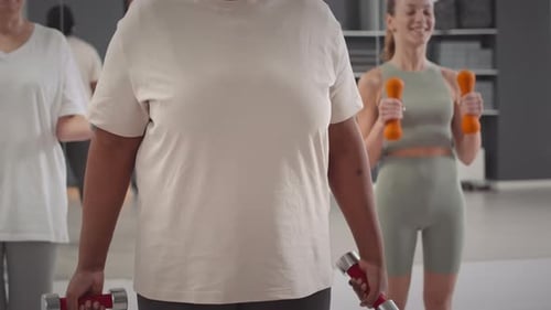 Women Working Out With Dumbbells in Gym