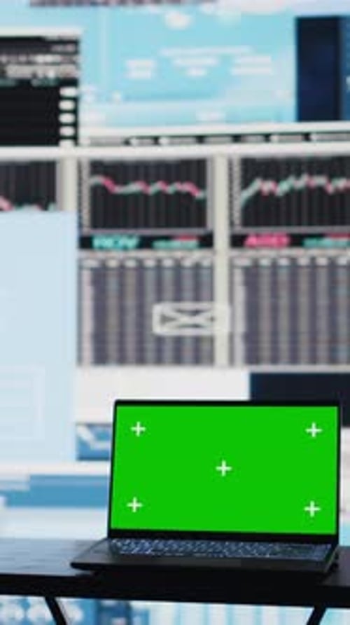 Vertical Video Laptop with Copy Space Display on Empty Desk Next to Infographics Reports