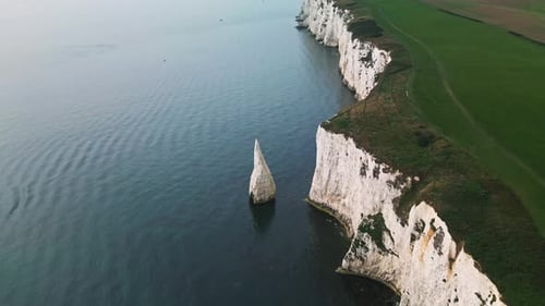 Old Harry Rocks Poole establishing shot over green grass and rocks. Wide angle fly over