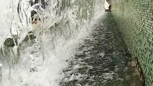 A
água cai de perto ou da fonte para uma pequena piscina na cidade. Câmera lenta