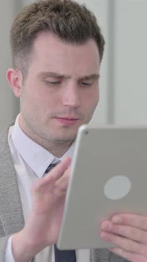 Man in Suit Uses Tablet in Office Setting
