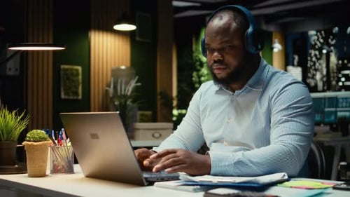 African American Guy Handles Daily Tasks Late at Night with Ambience Music