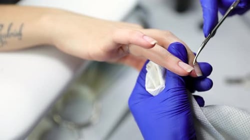 Manicurist Clipping Cuticles on Woman's Hand