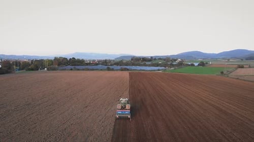 Tractor cultivating ground dry field.